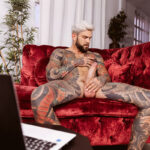 Well hung gay man with tattoos plays with his cock and balls.